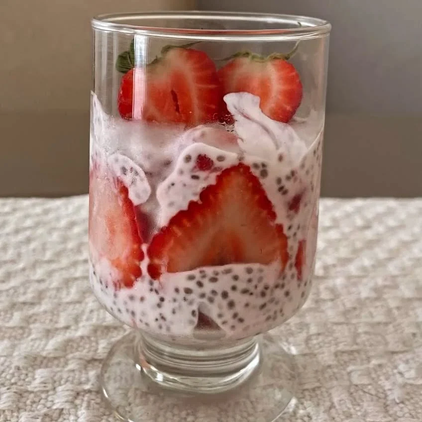 Copo com pudim de chia, iogurte e morangos, uma opção de café da manhã preparada pela Marianne