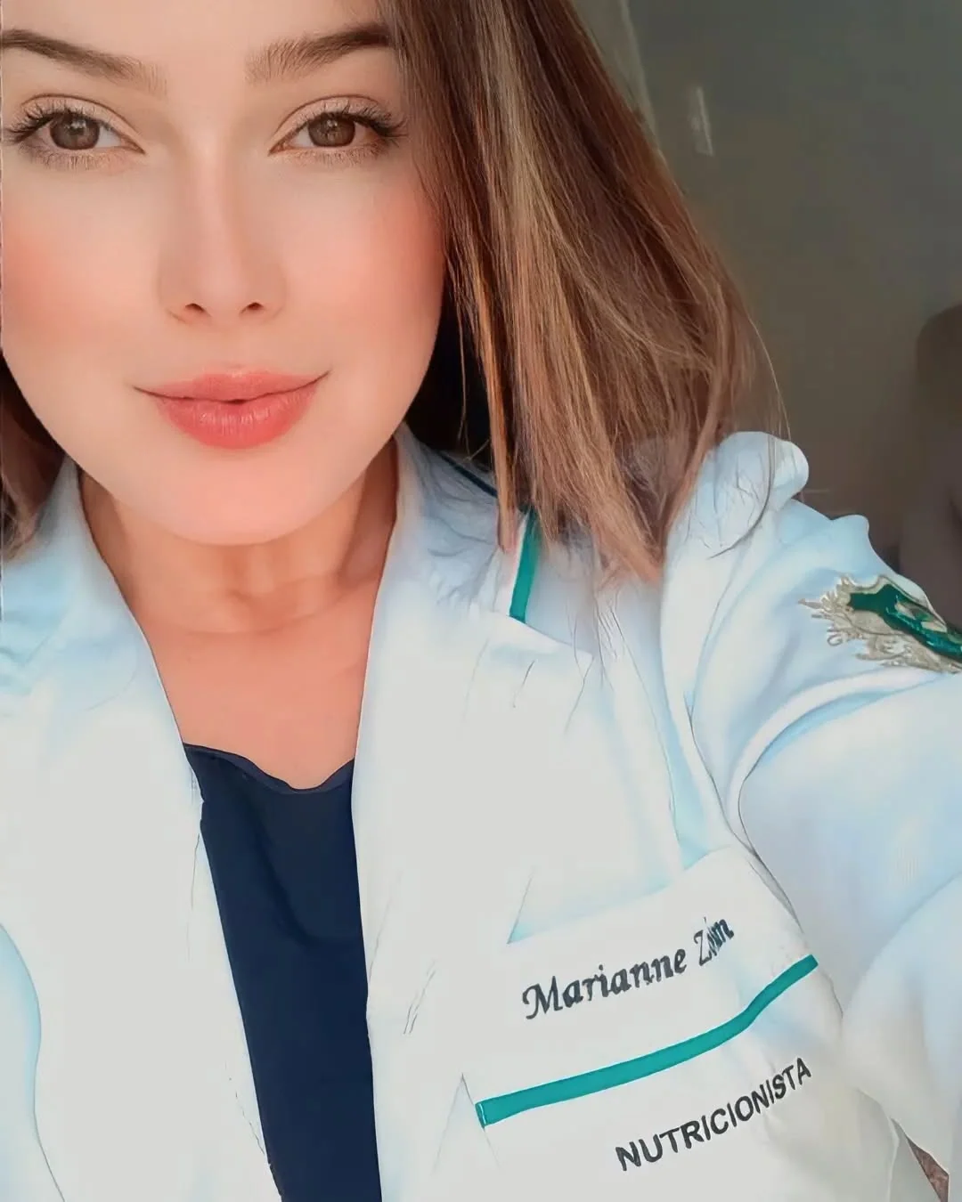 Marianne Zordan de jaleco de nutricionista, com o nome bordado